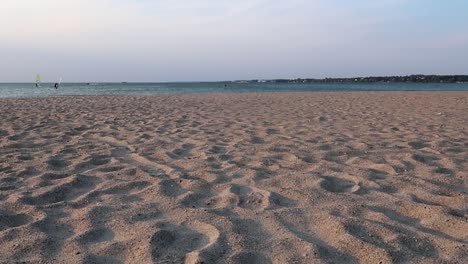 hand dropping some sand at the beach at dawn