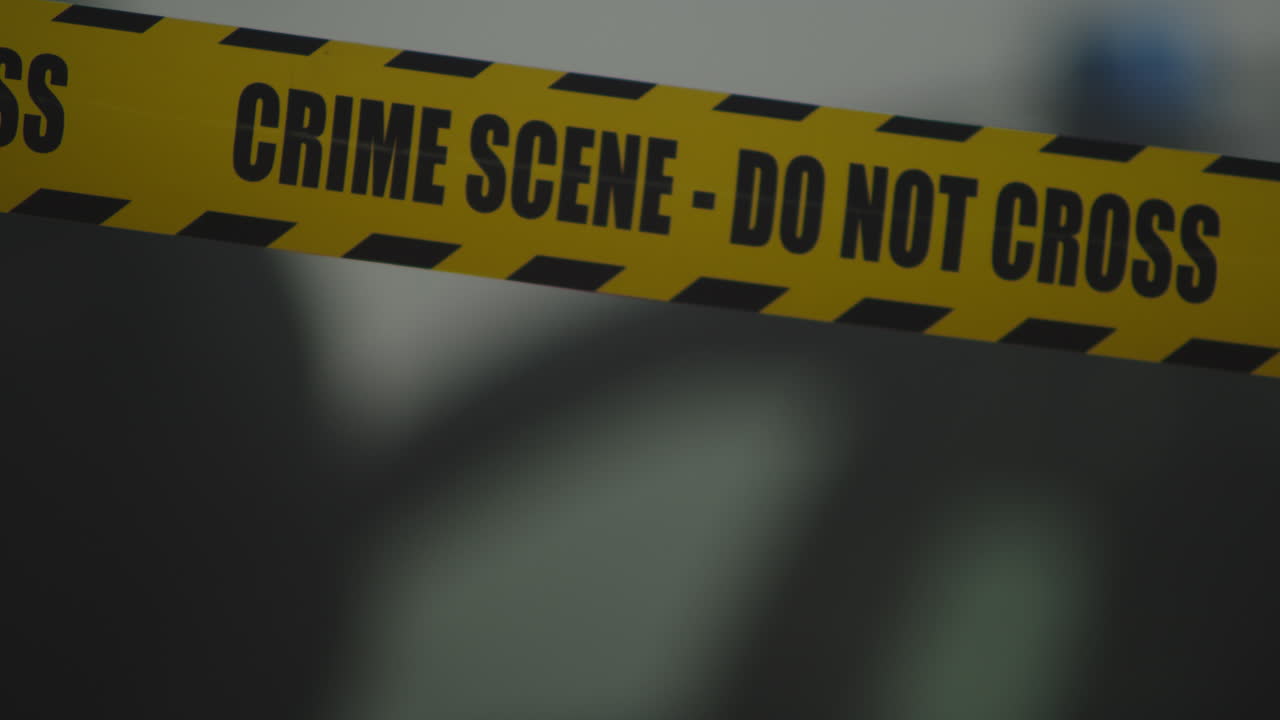 Behind the police tape do not cross, crime scene, two police officers get out of the car