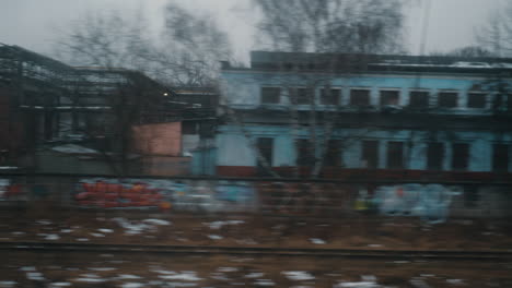 looking at dull autumn city from moving train russia