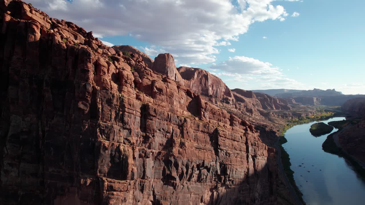 Toma de dron ascendiendo por el lado de un acantilado a las afueras de Moab, Utah, a lo largo del río.