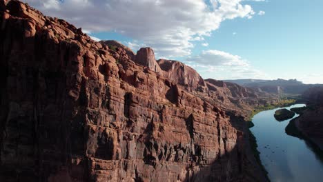 drone shot scaling up the side of a cliff outside of moab, utah along the river