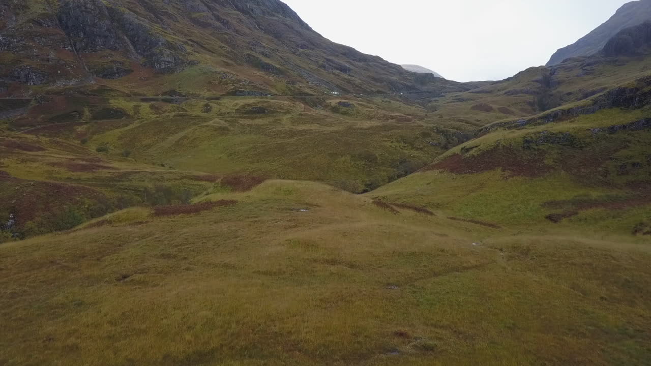 험준한 스코틀랜드 고원의 언덕이 많은 잔디 계곡의 고속도로, 공중
