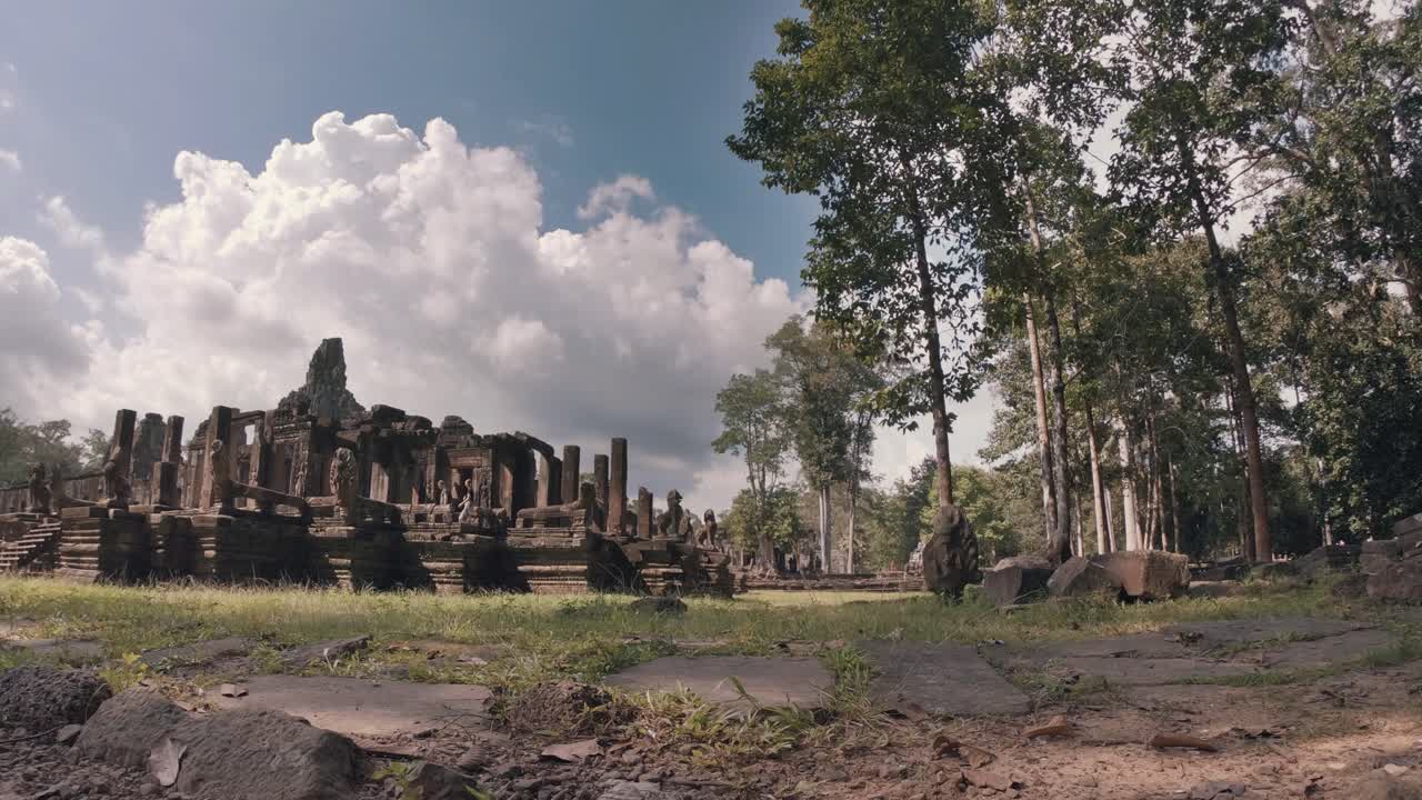 Timelapse of Temple at Angkor Wat Complex Amongst the Trees with Fluffy White Clouds