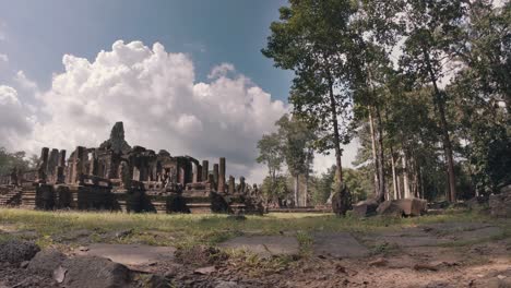 timelapse of temple at angkor wat complex amongst the trees with fluffy white clouds