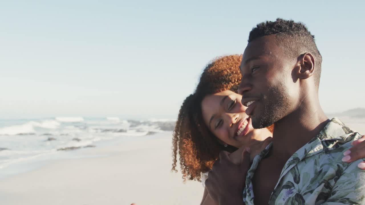 una pareja afroamericana disfrutando de la vista del mar
