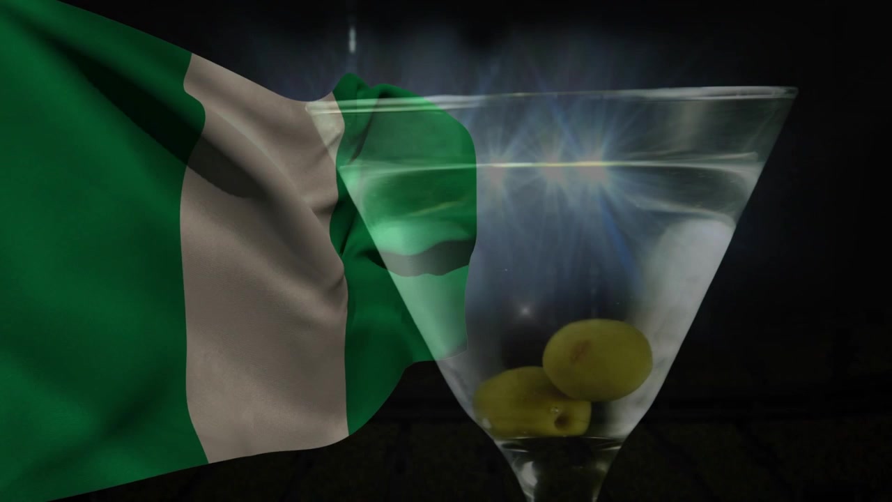 Ráfaga de viento empujando una bandera verde ondeando en el centro, pasando una copa de martini que refleja la luz para un efecto de capas.