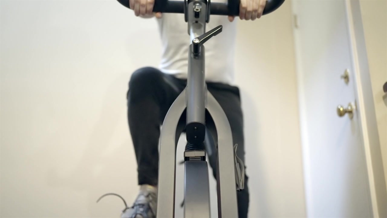 Person cykler på motionscykel derhjemme for daglig træning