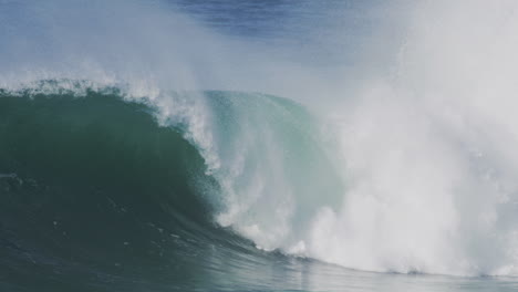 surfer carving through a massive wave in slow motion during golden hour, with water spray and dramatic lighting