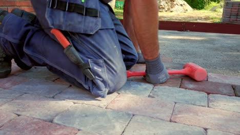 el pavimentador profesional apila las piedras rojas.