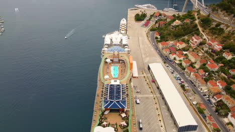 La-Gente-Nada-En-La-Piscina-En-La-Cubierta-Del-Crucero-Atracado-En-El-Puerto-De-Dubrovnik,-Croacia