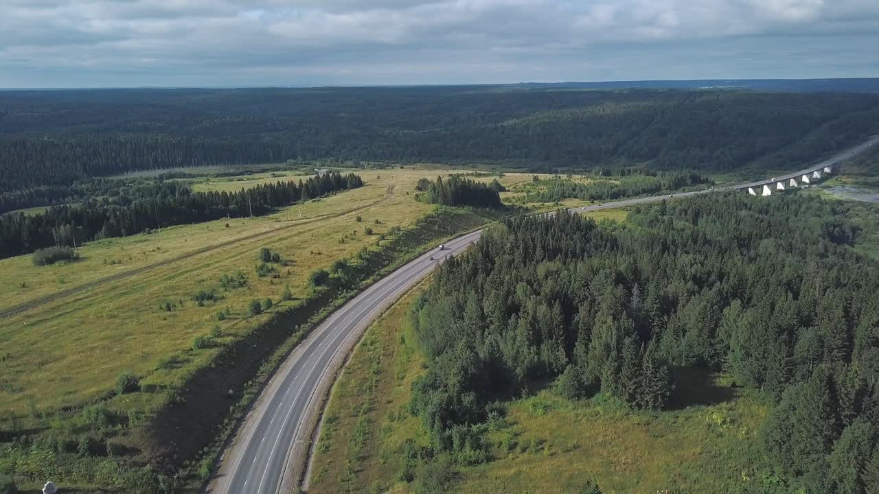 vista aérea de una carretera sinuosa a través de bosques y campos