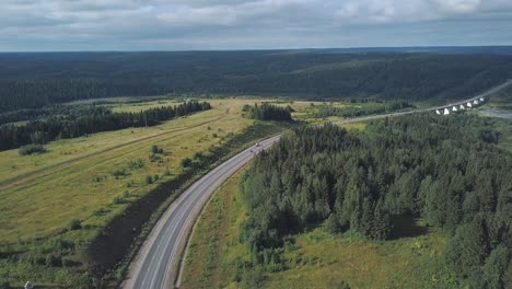 aerial view of a winding highway through forest and fields