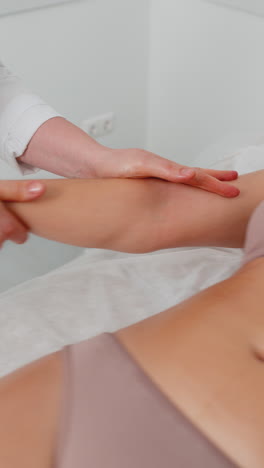 cosmetólogo masajista haciendo tratamiento de mujer masaje fregando la mano con fregado en la clínica de spa