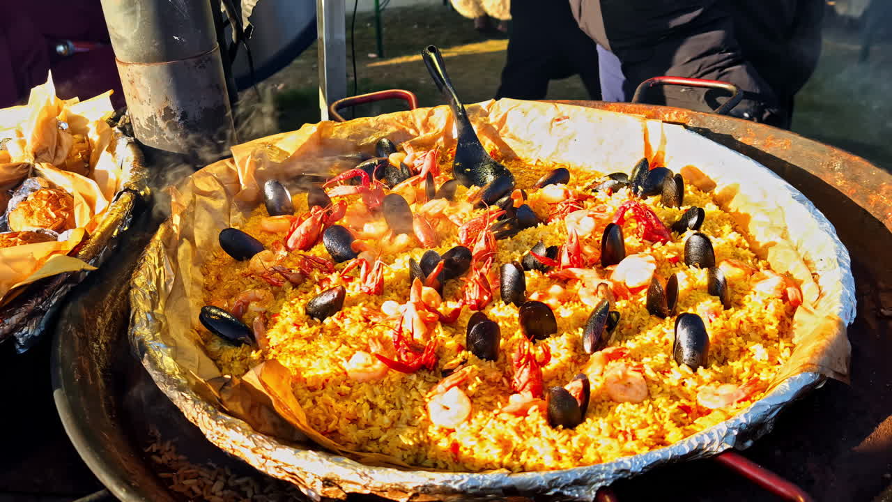 Mercato di street food in Lettonia con una grande padella di paella di frutti di mare colorata