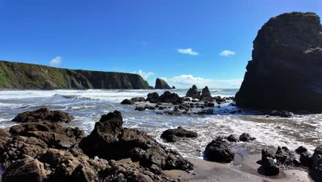 las mareas entrantes rápidas en la bahía de ballydwane en la marea alta de primavera en la costa de cobre en waterford, irlanda