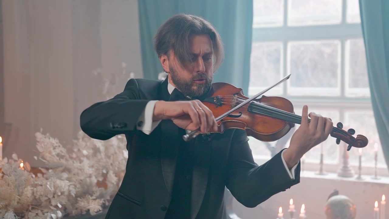 Uomo elegante in completo che suona il violino in un ambiente formale