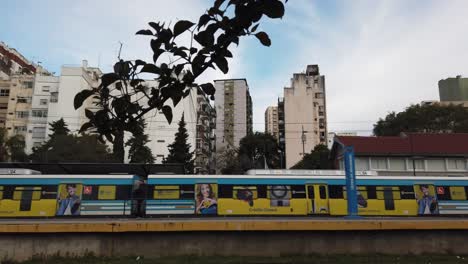 caballito railway station establishing shot panoramic, train departing suburban city