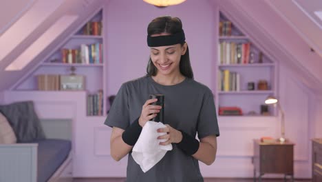 Happy-Indian-woman-wiping-sweat-and-drinking-water