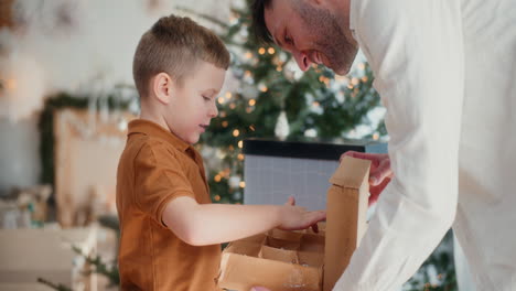 young boy and father decorating tree and preparing christmas decorations