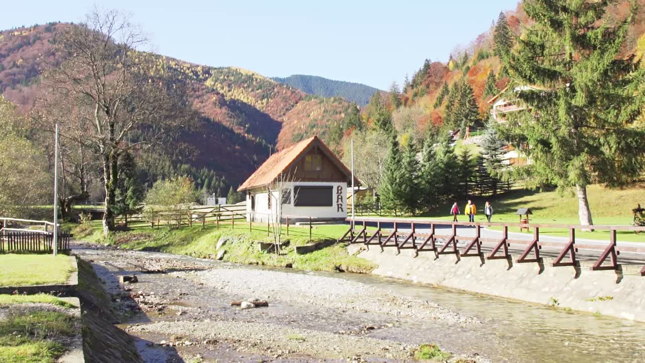 Vaeltajia kävelemässä pienen baarin lähellä joen pengereellä aurinkoisena päivänä Piatra Craiului -vuoristossa, Brasovissa, Romaniassa