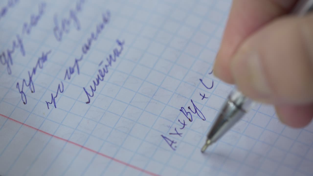 Person writing math equations in a notebook
