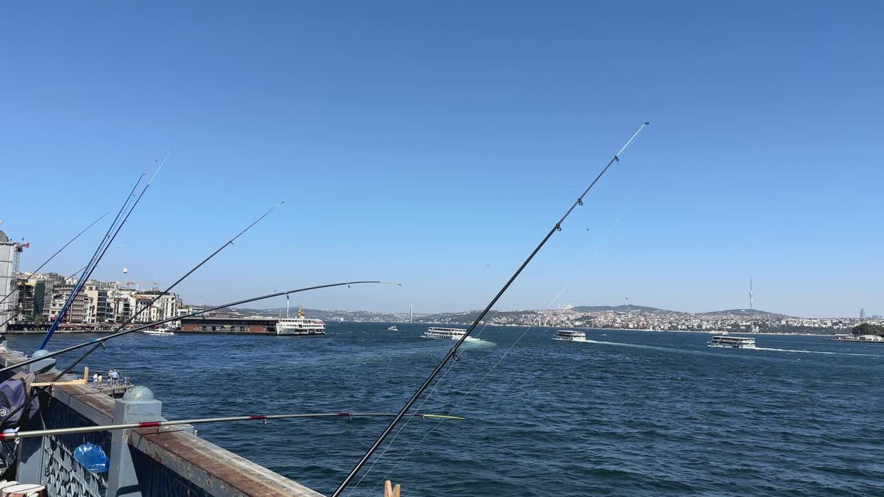 Pescatori e canne da pesca sporgono da un ponte nel fiume alla periferia di Istanbul, Turchia