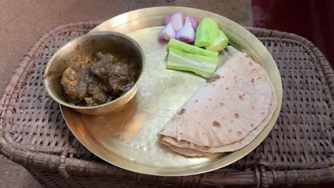 shot of roti and mutton served in brass plate