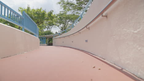 Low-angle-shot-moving-up-a-ramp-in-a-peaceful-park-in-Hong-Kong