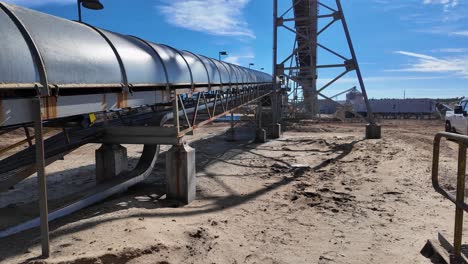 pov shot of a large conveyor belt at wood pellet processing plant