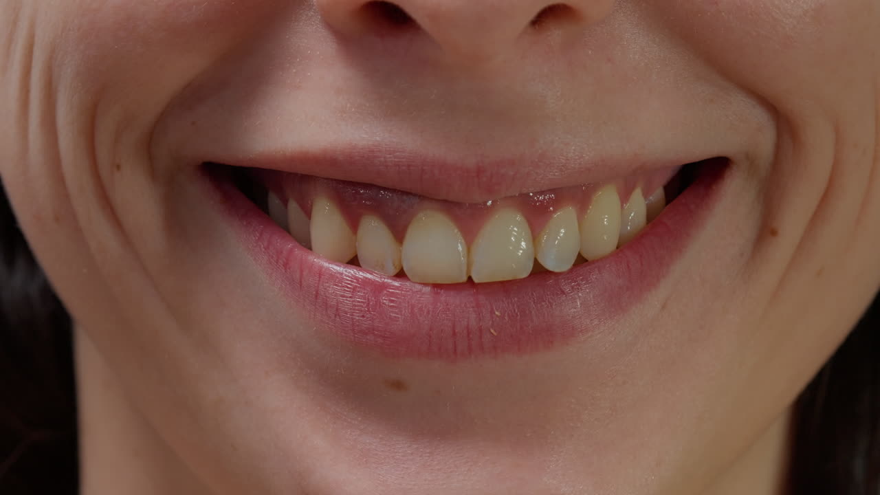 Macro shot of female model smiling and moving lips on camera