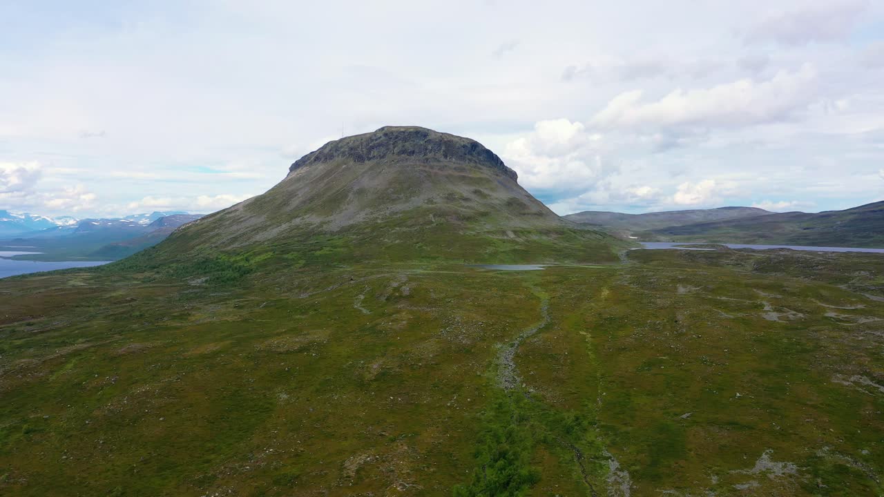 Aerial view of the Saana fell and boreal wilderness, cloudy, summer day, in Kilpisjarvi, Enontekio, Lapland, Finland - tracking, drone shot
