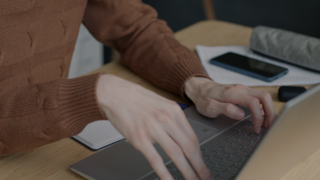 persona escribiendo en una computadora portátil en un escritorio