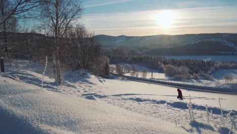 Young-Boy-Pulling-Sled-Through-Heavy-Thick-Snow-On-Hillside-In-Norway