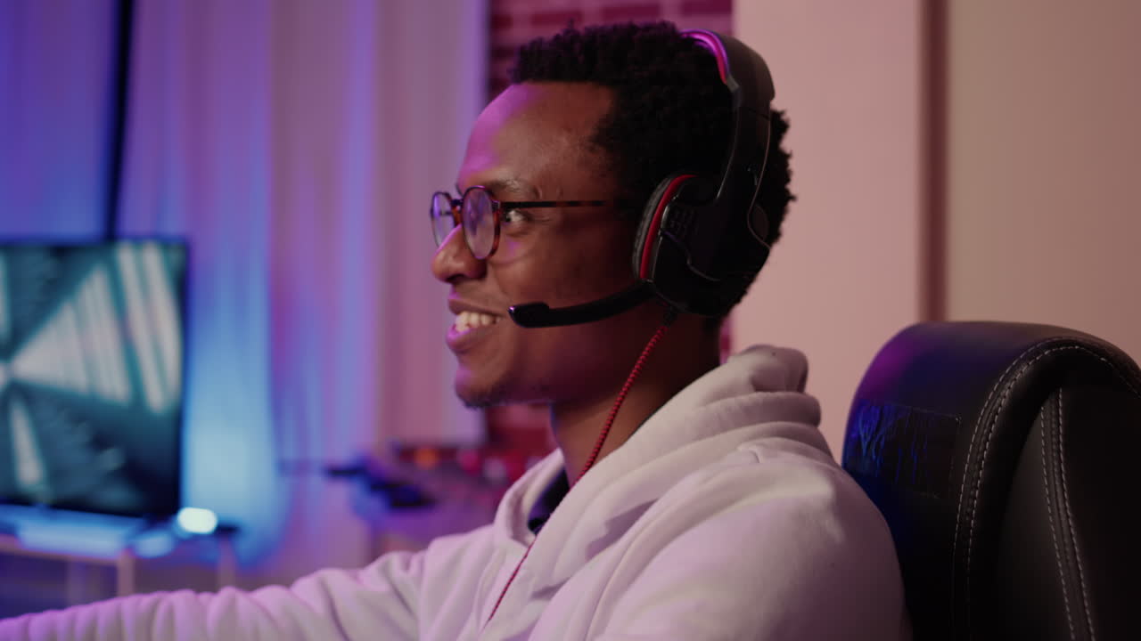 Closeup of african american gamer with gaming headset talking to team members in multiplayer game