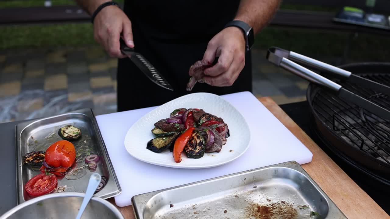 요리사는 채소와 함께 그릴 스테이크를 준비하고 있습니다.