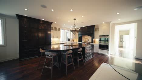 a large luxury kitchen with dark wood finishes and a large kitchen island