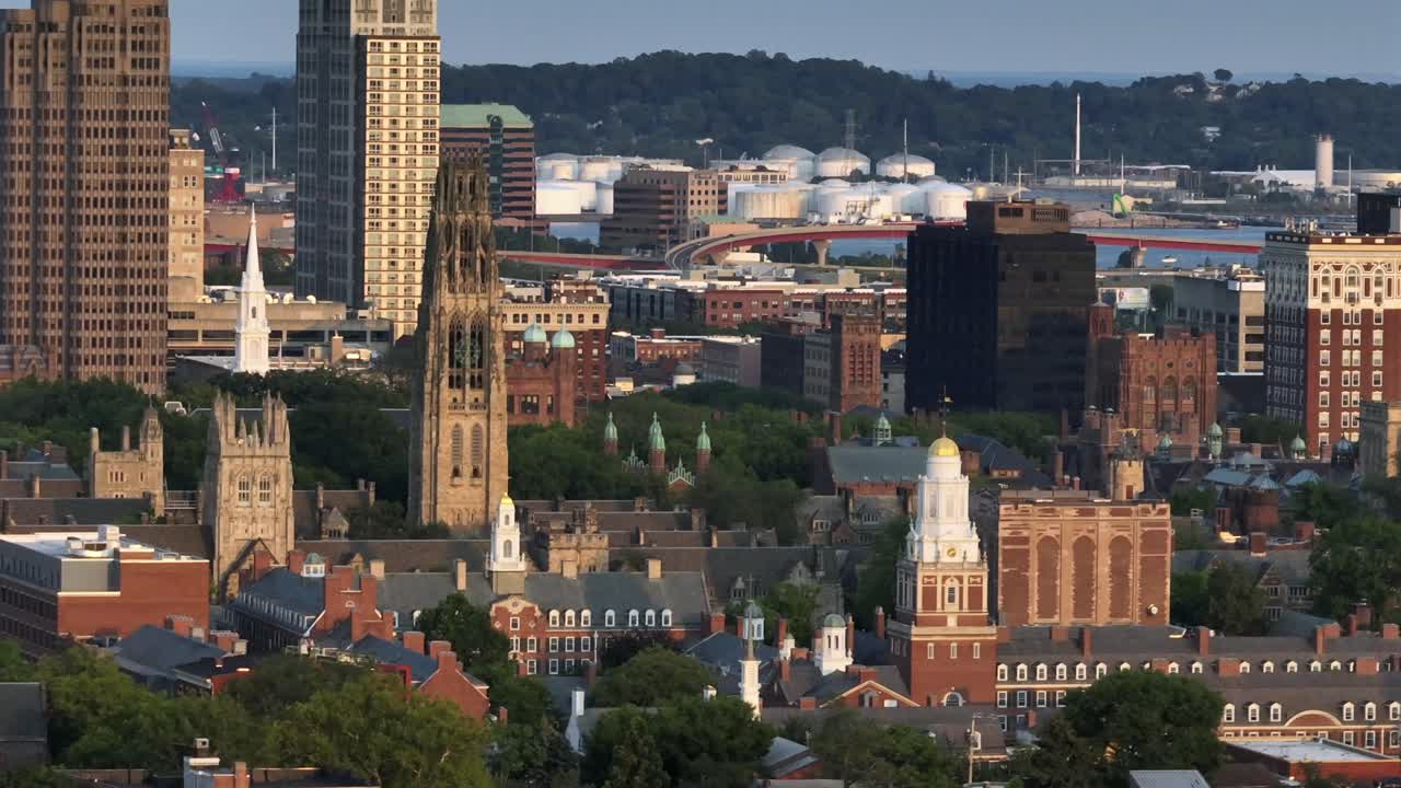 Aerial zoom of historic cathedral and harkness tower in New Haven, Connecticut. Wide shot. Old University and downtown buildings in center. Sunset time