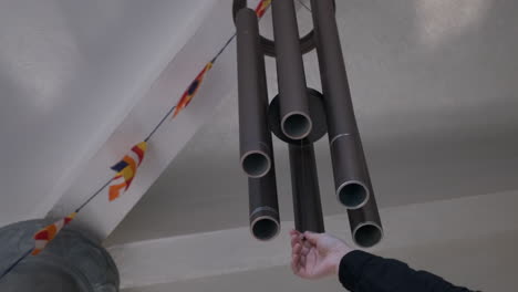primer plano de una campana de viento de metal gris oscuro colgando del techo