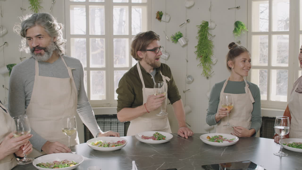 Group of people enjoying a meal and drinks in a kitchen