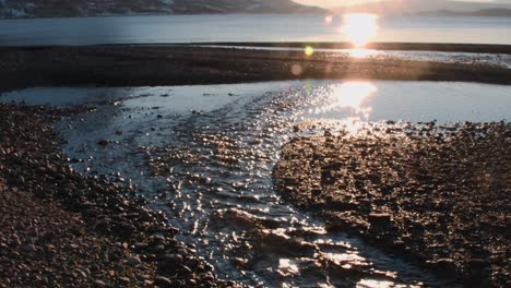 small creek flushing over stones in very cool sunset