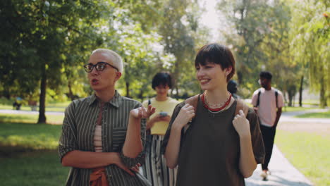 teacher and college girl chatting on walk in park