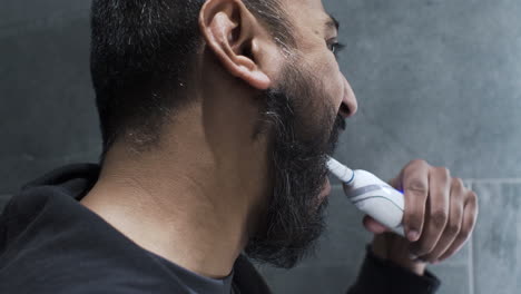 ethnic minority adult male using electric toothbrush