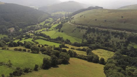 Aerial-view-idyllic-vast-lush-green-rural-misty-mountain-valley-countryside-push-in