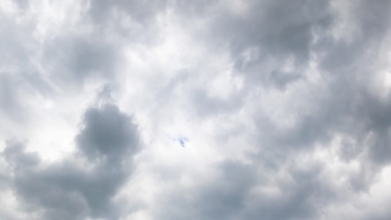 Dramatic grey cloudscape covering the sky. Stormy clouds accumulation from low angle view. Timelapse.