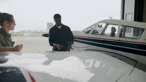 aircraft mechanic explaining details of airplane repair to colleague