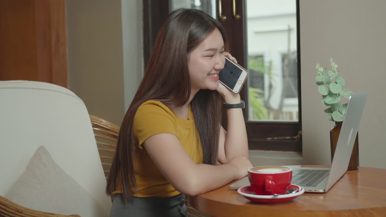 Young Asian Girl Looking Outside At A Coffee Shop With A Laptop