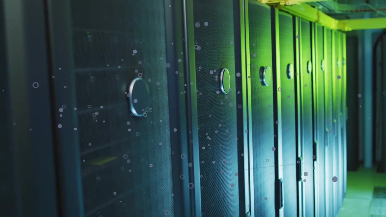 Camera tracking slowly through data center, revealing server racks with floating particles overlay