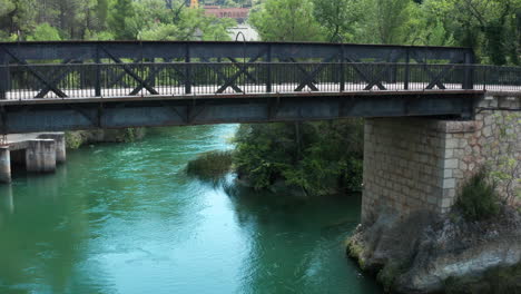 Descending-aerial-view-of-the-old-bridge-along-the-river