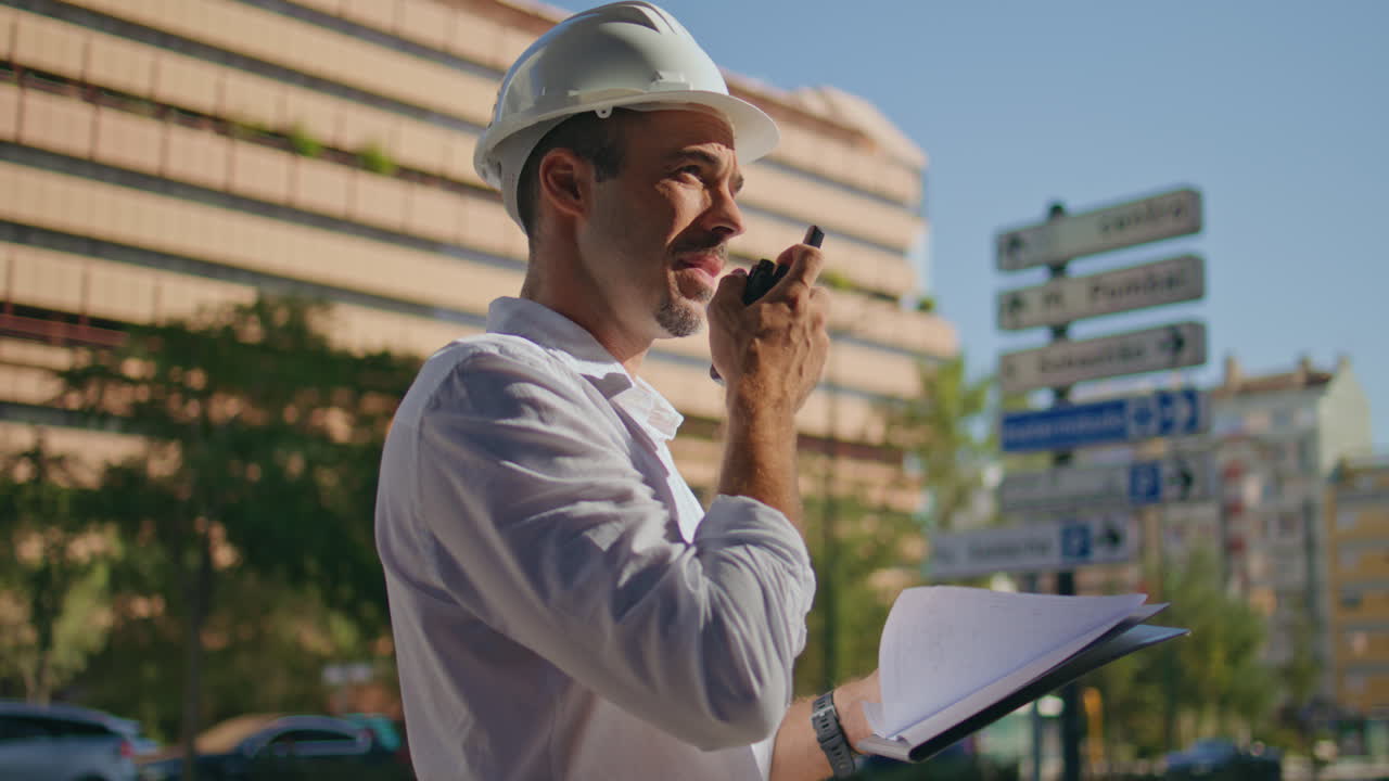 Building chief speaking wireless communicator sunlight downtown district closeup