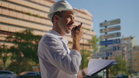 building chief speaking wireless communicator sunlight downtown district closeup